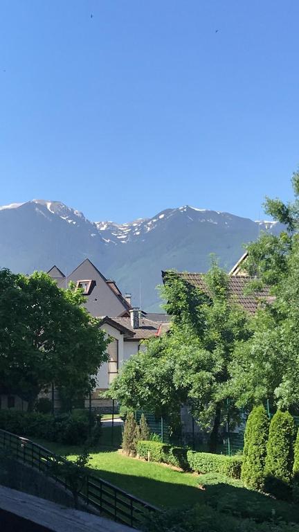 a house with trees and mountains in the background at Aspen Valley in Razlog