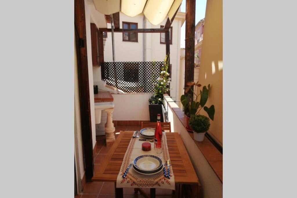 una habitación con una mesa con platos. en ÁTICO EXCLUSIVO EN EL CENTRO DE GRANADA, en Granada