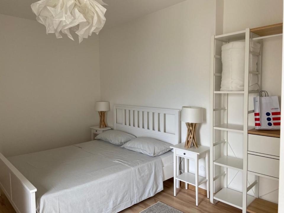 a white bedroom with a bed and shelves at B&B L'edera in Trento
