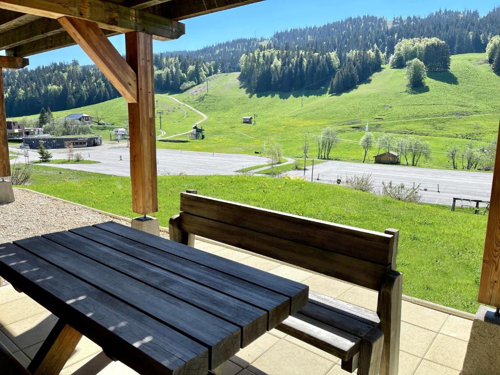 拉穆拉的住宿－Gîte avec terrasse et belle vue - ChaletNelda com，门廊上的木凳,享有美景