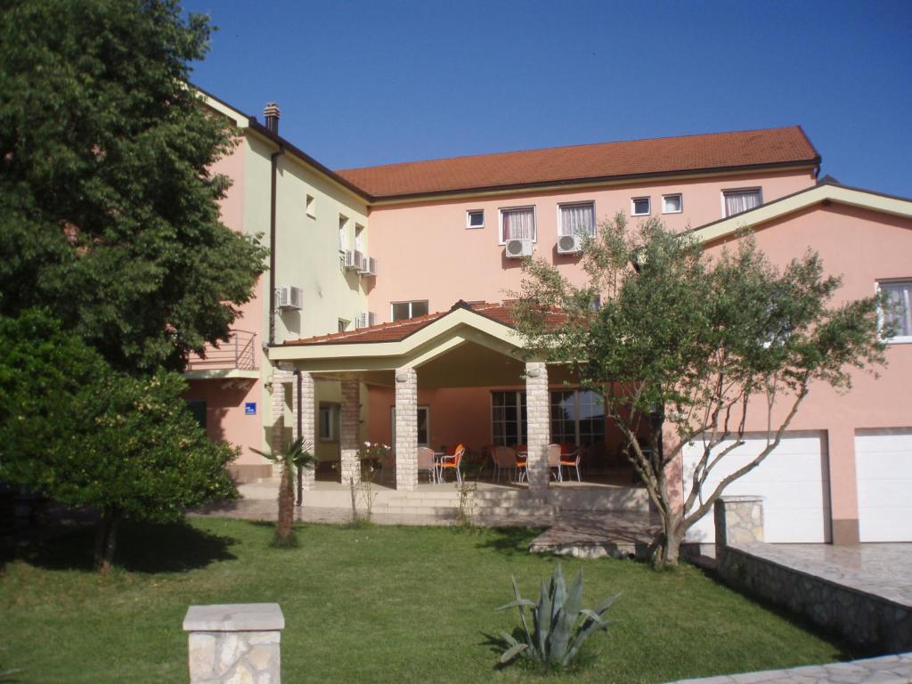 a large pink house with a yard at Hotel ''Marinko Kozina'' - Medjugorje in Međugorje