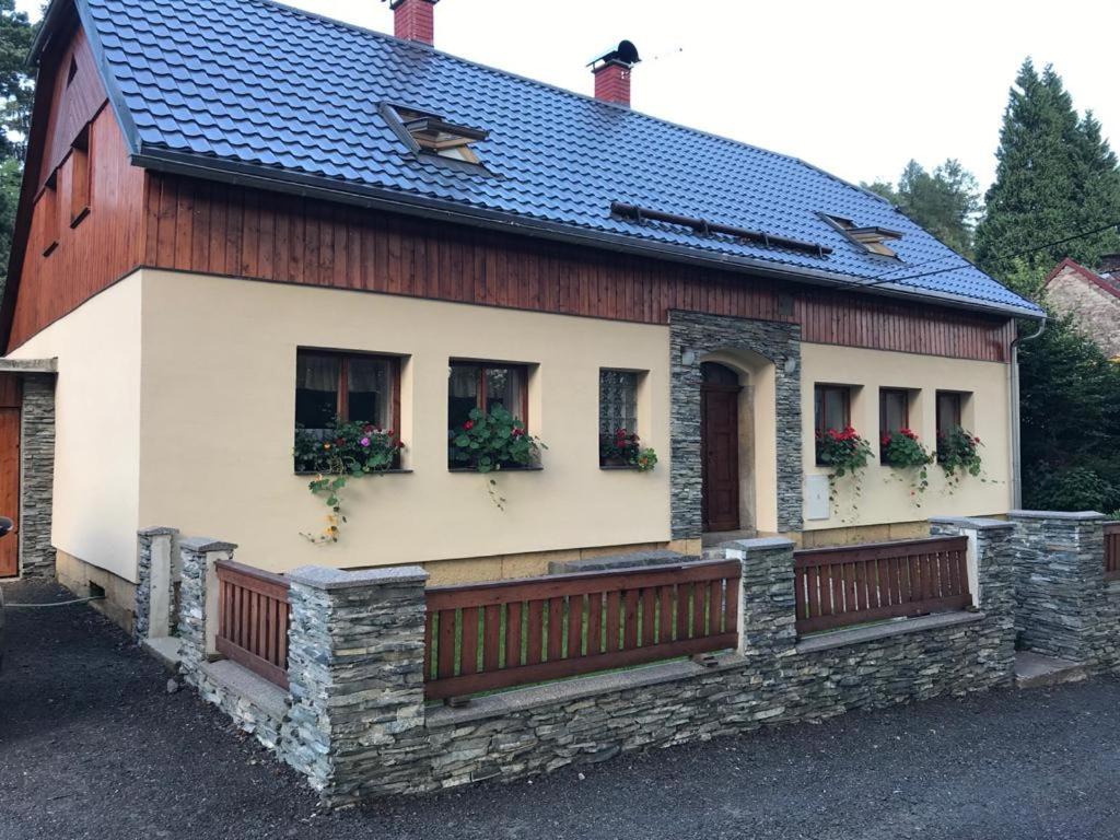 Casa roja y blanca con valla y ventanas en Chalupa Brtníky, en Staré Křečany