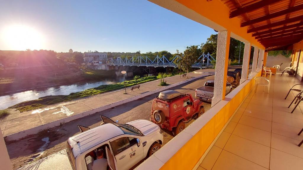 a building with cars parked on the side of a road at POUSADA BEIRA RIO in Ponte Alta do Norte