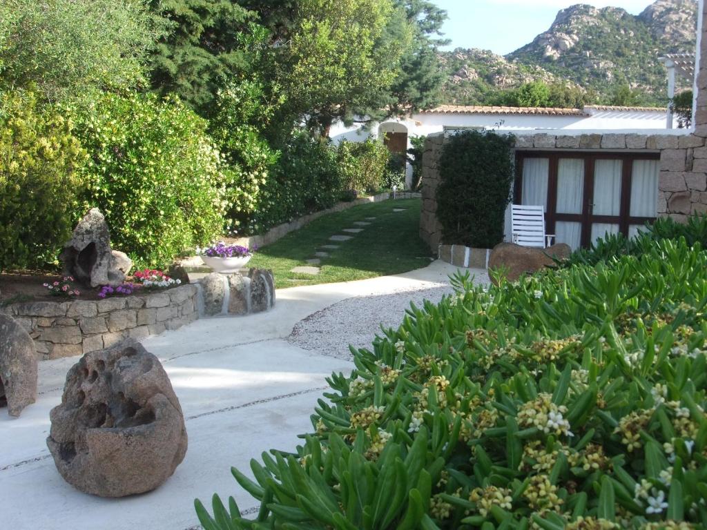 einen Garten mit Felsen und Pflanzen und ein Haus in der Unterkunft Residenza Nialiccia in Abbiadori