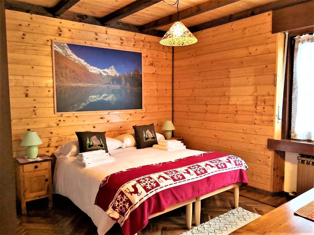 a bedroom with a bed in a log cabin at Maison Mont Rose in Valtournenche
