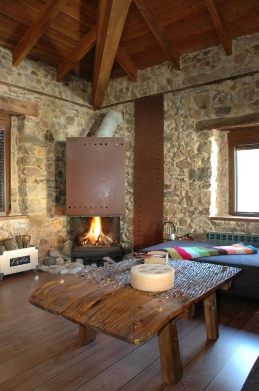 ein Wohnzimmer mit einem Kamin und einem Holztisch in der Unterkunft SUMERGETE EN LEON .CASA in Cofiñal