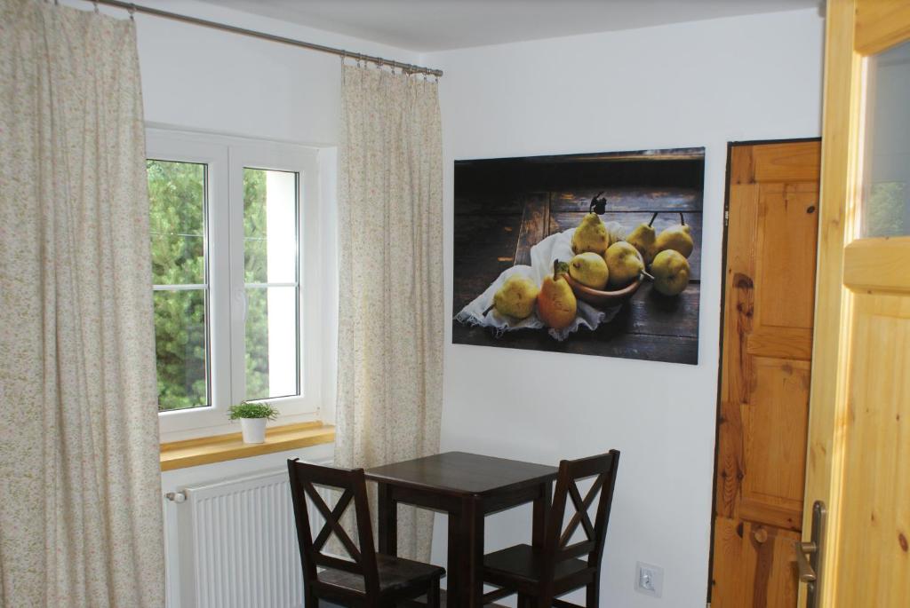 a table and chairs in a room with a picture on the wall at Karkonoski Sad in Piechowice