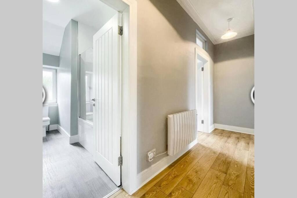 an empty hallway with a white door and wooden floors at No7 Oban Harbour in Oban