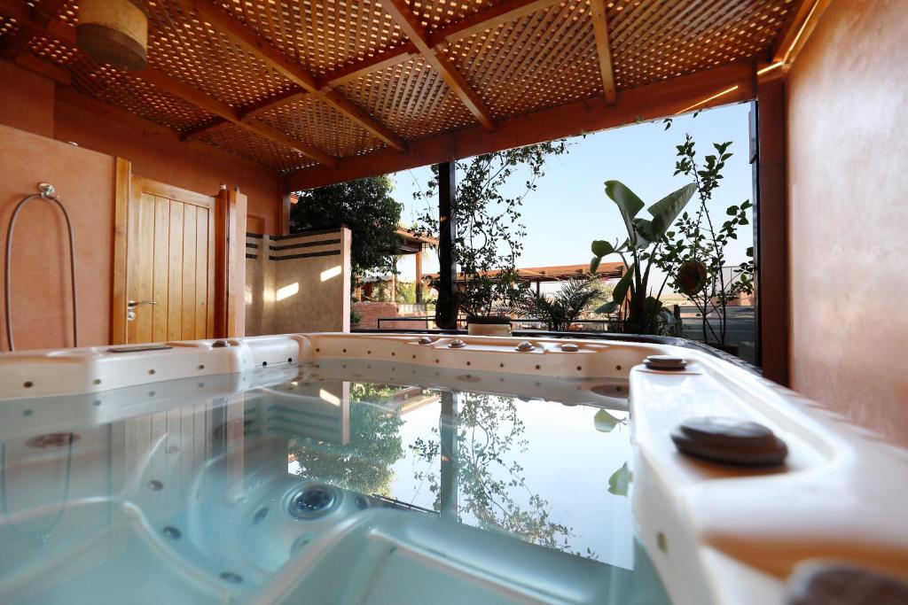 uma banheira de hidromassagem num quarto com uma grande janela em Riad L'Etoile D'Orient em Marrakech