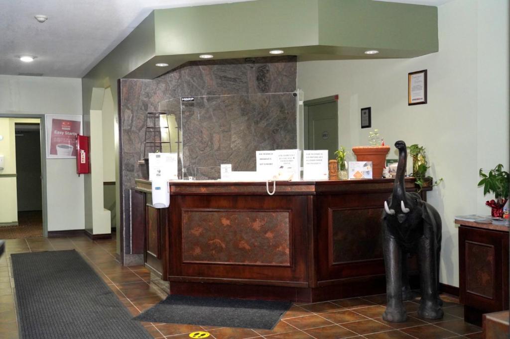 een lobby met een receptie en een grote spiegel bij Econolodge Huntsville in Huntsville