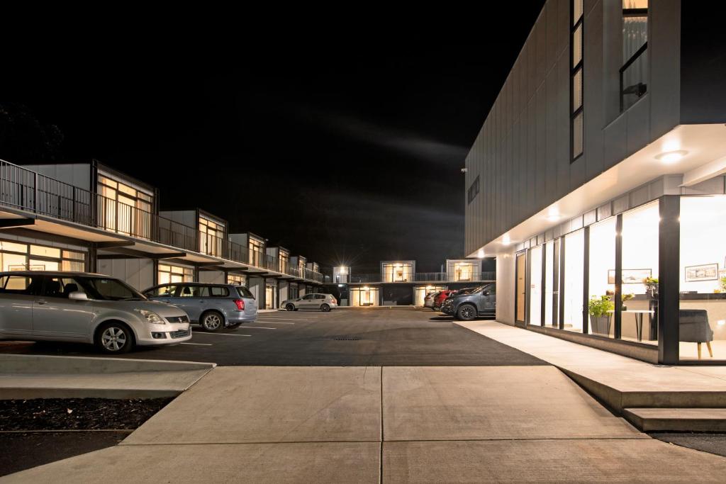 a parking lot with cars parked in front of a building at The Com Plex Motel in Whakatane