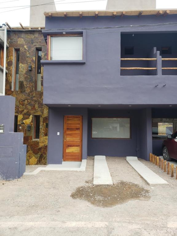 una casa azul con una puerta de madera y un edificio en Lo del Chango en Purmamarca