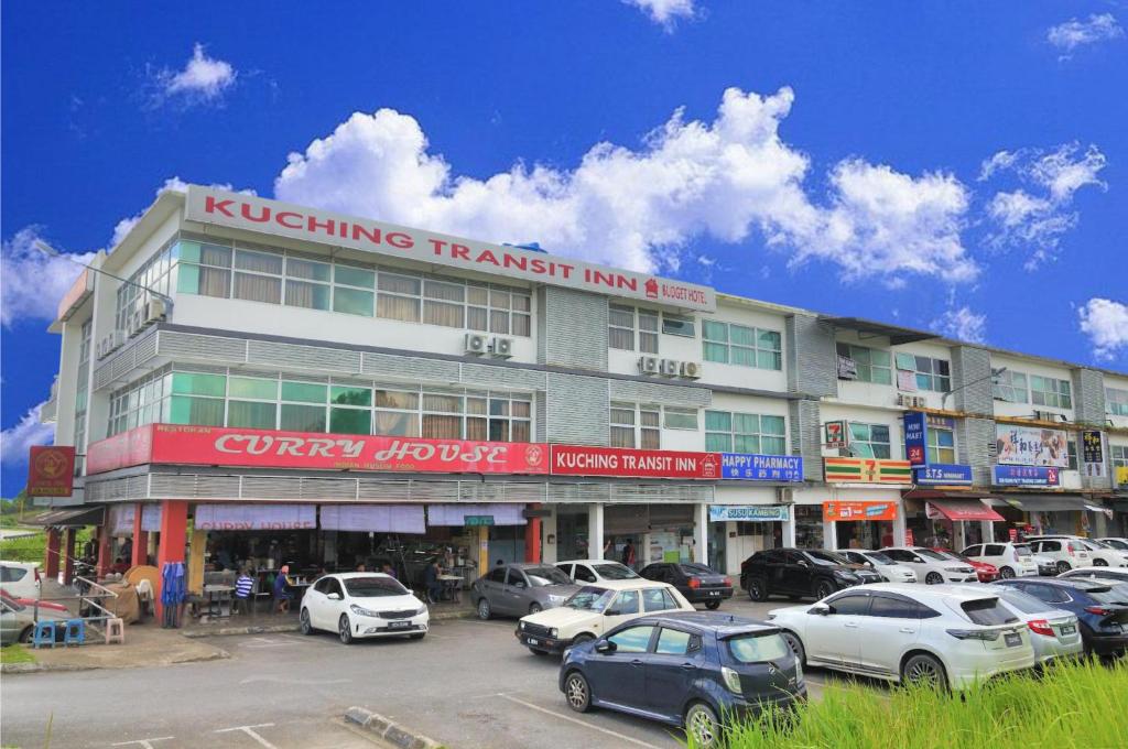 a building with cars parked in a parking lot at Kuching Transit Inn in Kuching