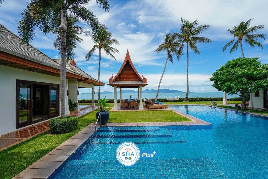- une piscine en face d'une maison avec des palmiers dans l'établissement Miskawaan Villa Lotus, à Mae Nam Beach