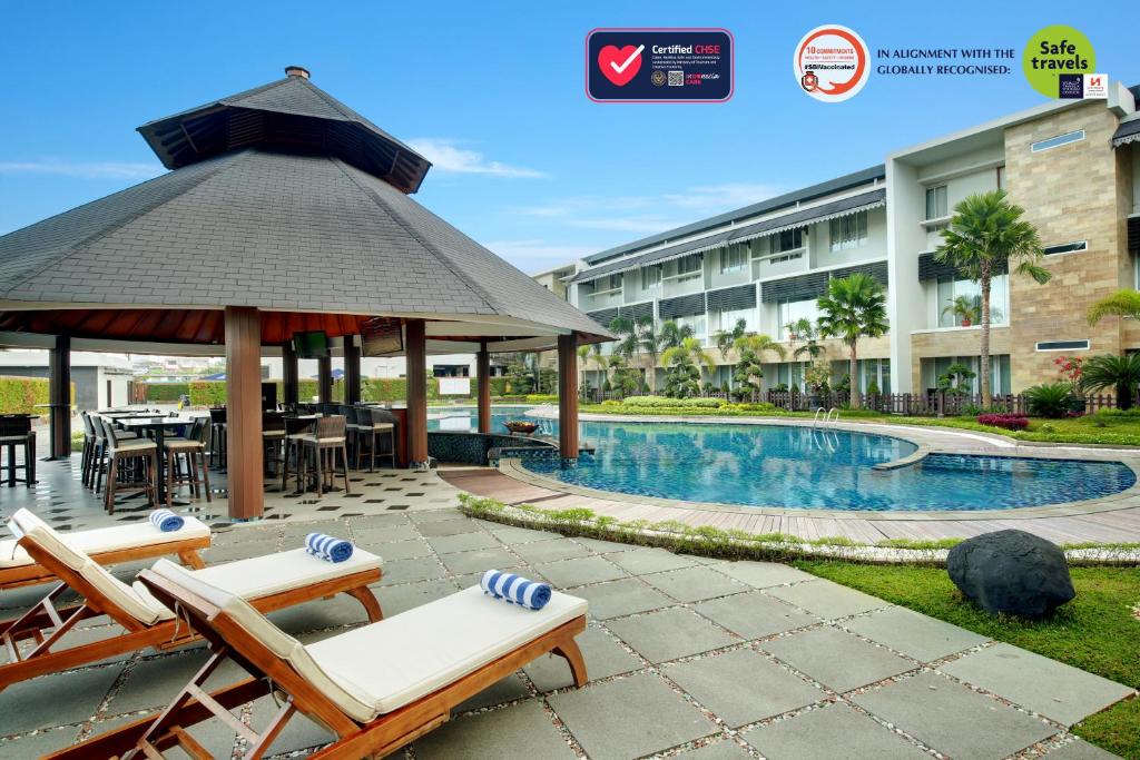 a hotel with a gazebo and chairs and a pool at Swiss-Belhotel Borneo Banjarmasin in Banjarmasin