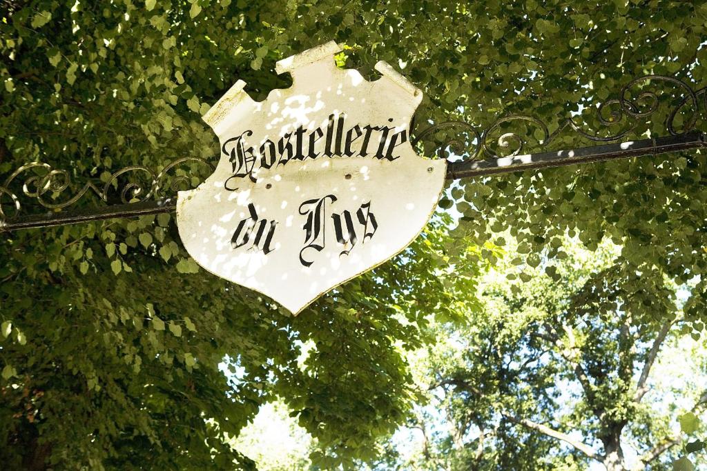 una señal que está pegada a un árbol en Hostellerie Du Lys, en Lamorlaye