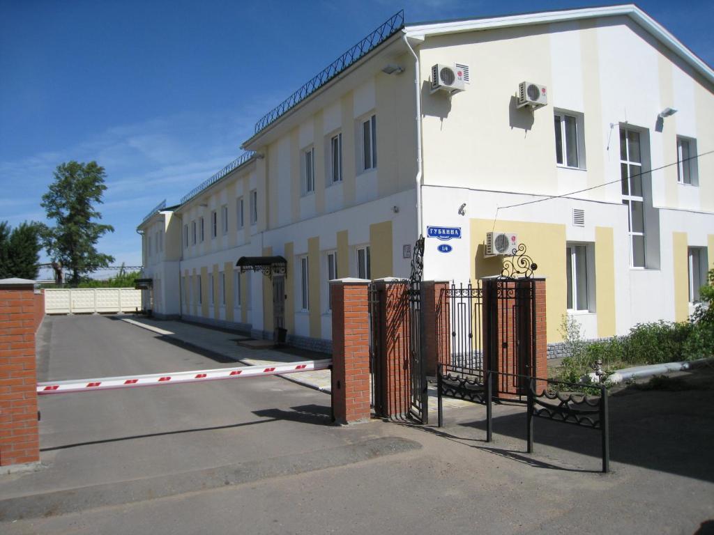 a white building with a gate in front of it at Podkova Omsk na Prospekte Gubkina in Omsk