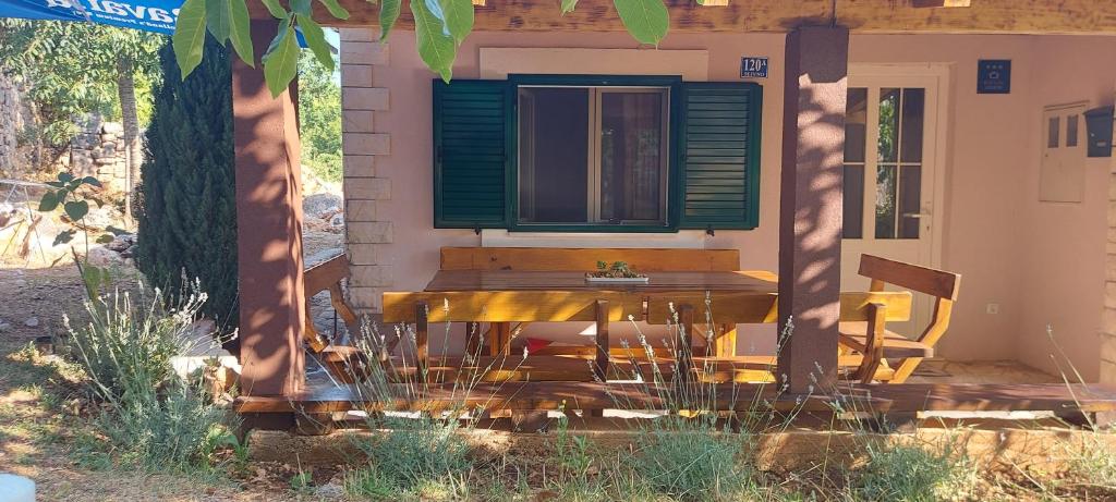 a table and a chair sitting outside of a house at Holiday home Frane in Slivno