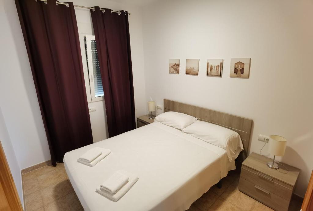 a small bedroom with a white bed and a window at Villa Patri in Benissa