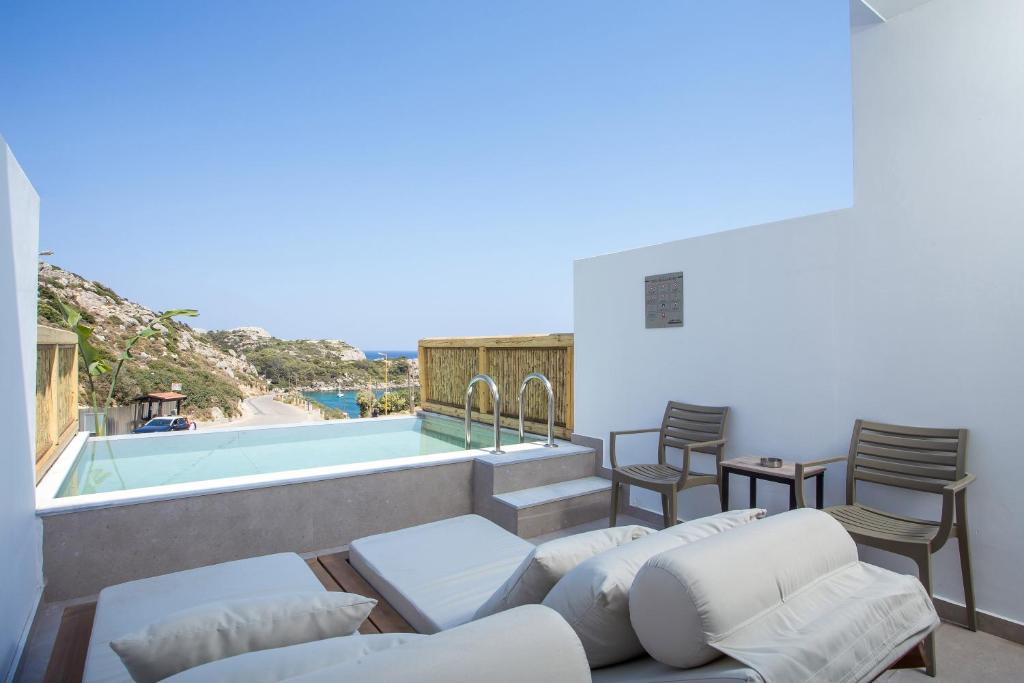 een patio met stoelen en een zwembad bij Ladiko Suites - Faliraki in Faliraki