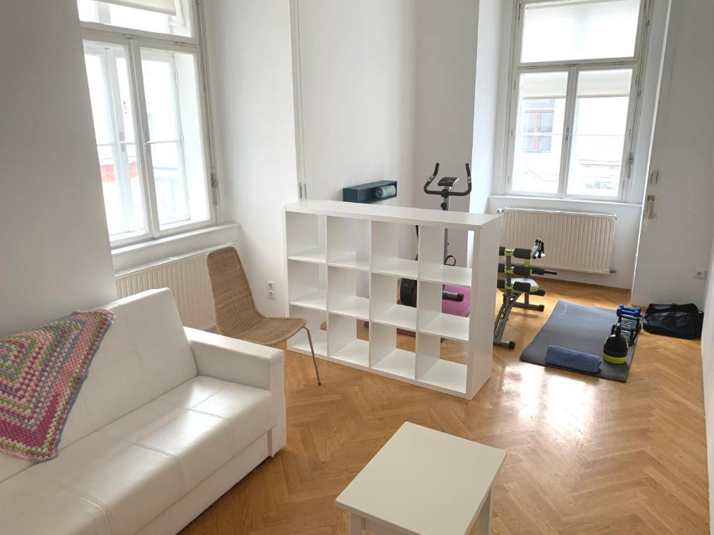 uma sala de estar com um sofá branco e uma mesa em Sobieski Stefansdom Apartments em Viena
