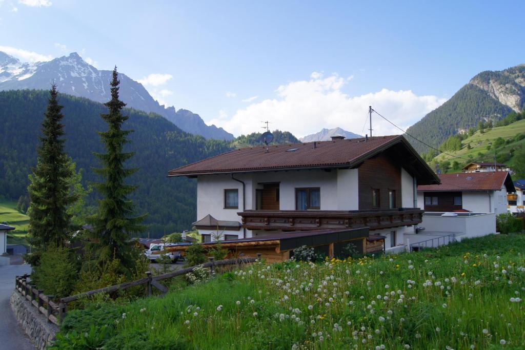 ein Haus auf einem Hügel mit Bergen im Hintergrund in der Unterkunft Ferienhaus Peter Spöttl in Nauders