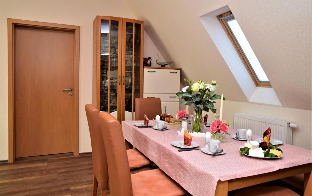 a dining room with a pink table with flowers on it at Ferienwohnung Anneliese am Stadttor in Hornbach