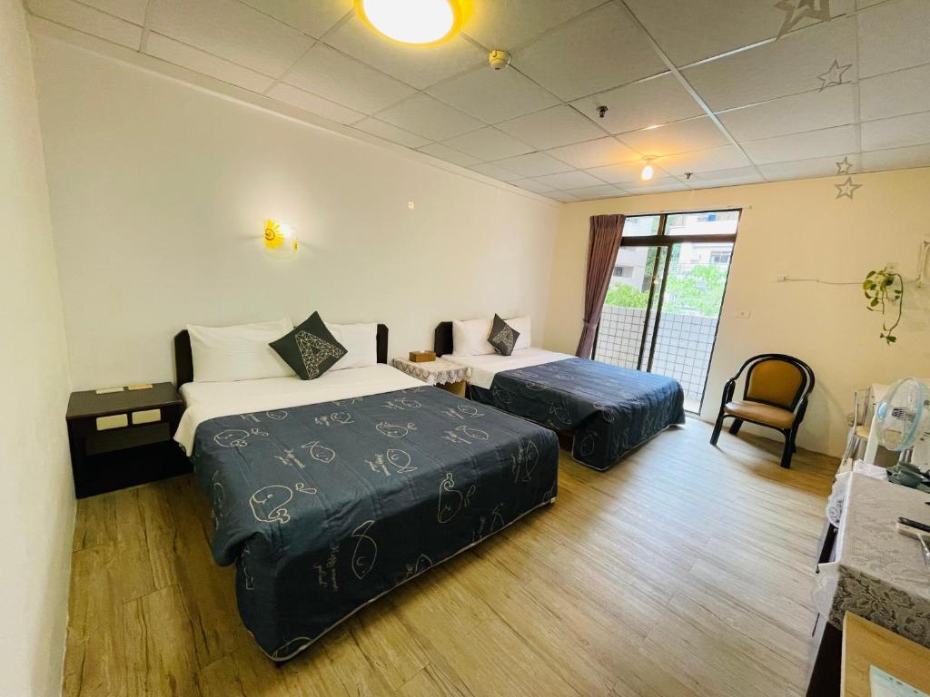 a hotel room with two beds and a chair at Zhiben Hotspring in Wenquan