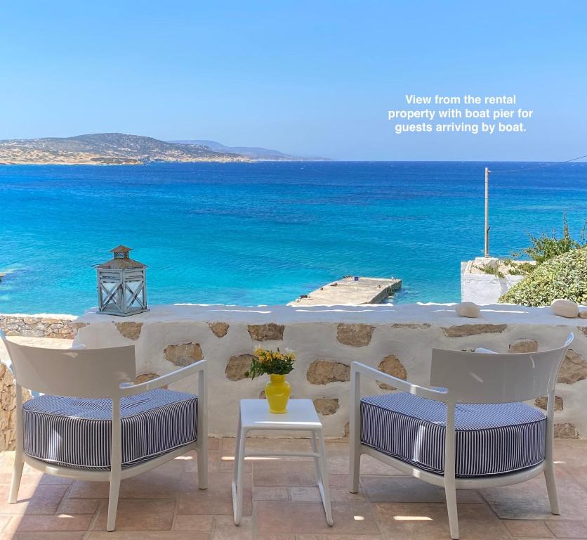 two chairs and a table with a view of the ocean at VillaRentalKoufonisiGreece in Koufonisia