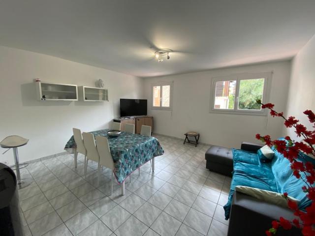 un salon avec une table et un canapé bleu dans l'établissement T3 pont romain Amelie les bains, à Amélie-les-Bains-Palalda