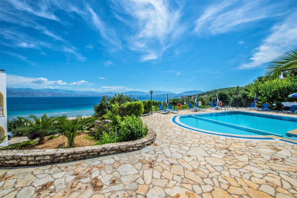 a resort pool with a view of the ocean at Dionysos Apartments in Apraos
