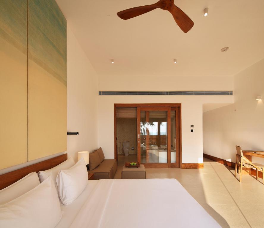 a bedroom with a bed and a ceiling fan at Riff Hikkaduwa in Hikkaduwa