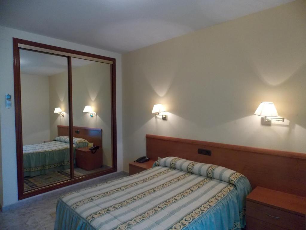 a bedroom with a bed and a large mirror at Hotel San Cristobal in Coria