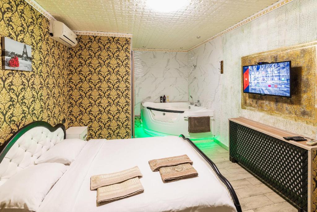 Смарт Апартаменты джакузи في دنيبروبيتروفسك: غرفة نوم بسرير ابيض ومغسلة