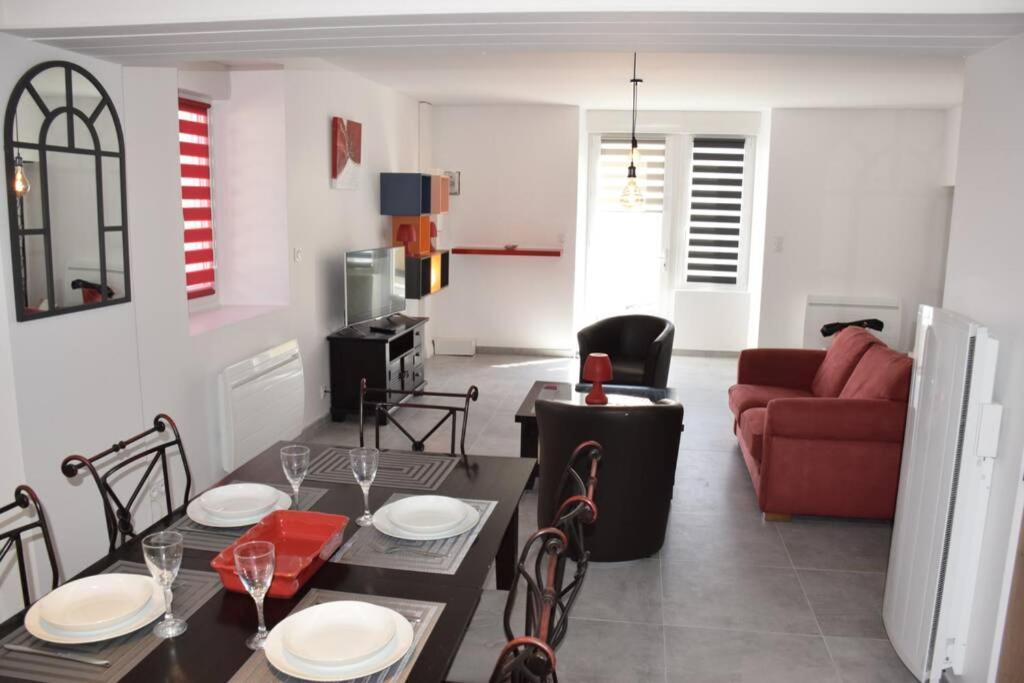 - un salon avec une table et un canapé rouge dans l'établissement A 20 mn du Puy du Fou coquette et fonctionellle, à Mauléon