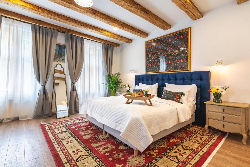 a bedroom with a large bed with a blue headboard at NIKOLAS HAUS with Free Parking in Braşov