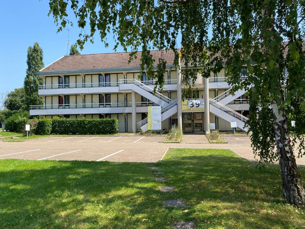 a building with a parking lot in front of it at Premiere Classe Avallon in Sauvigny-le-Bois