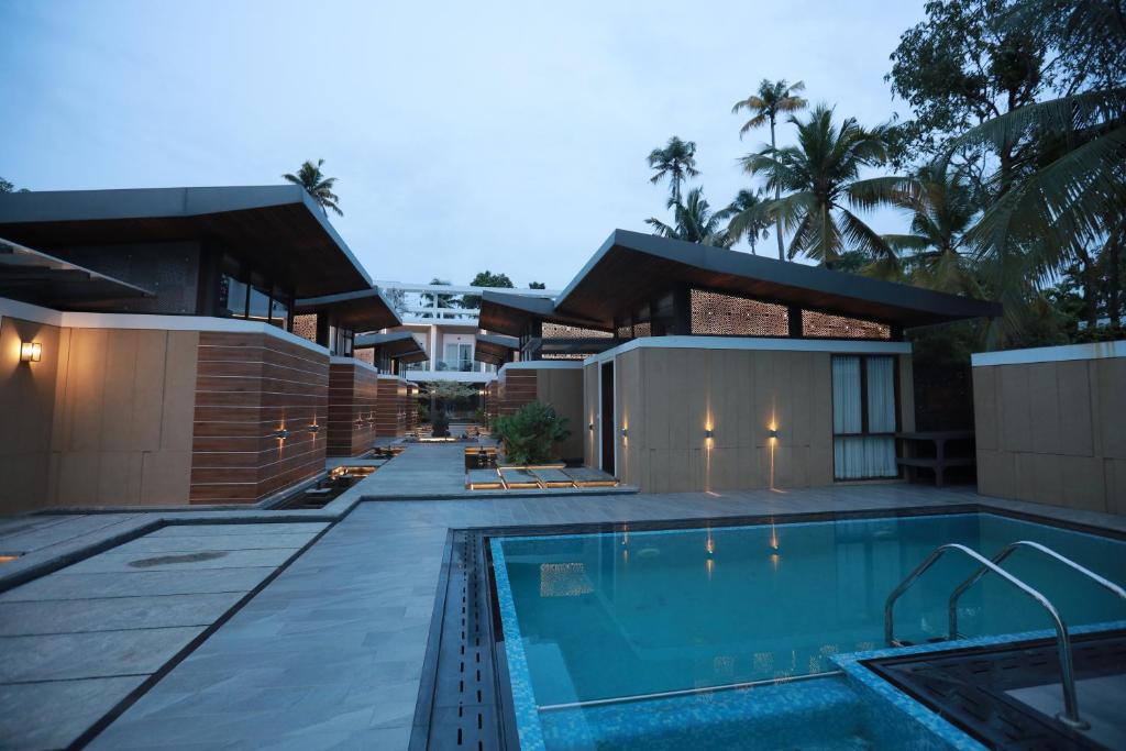 ein Haus mit Pool davor in der Unterkunft Lago Leisure Resort & Spa in Cherai Beach