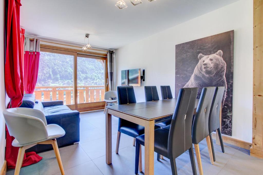 une salle à manger avec une table et une photo d'ours sur le mur dans l'établissement ALTAKA 3, à Morzine