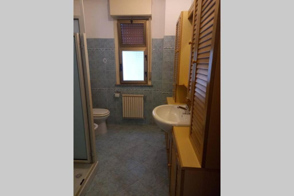 ein Bad mit einem Waschbecken und einem WC in der Unterkunft Lontano dal caos a due passi dal mare in Condrò