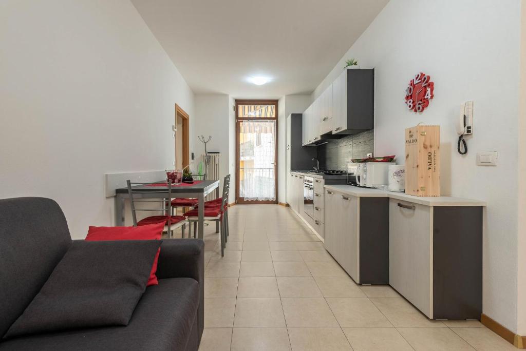 Il comprend un salon et une cuisine avec un canapé et une table. dans l'établissement Appartamento Madeleine, à Riva del Garda