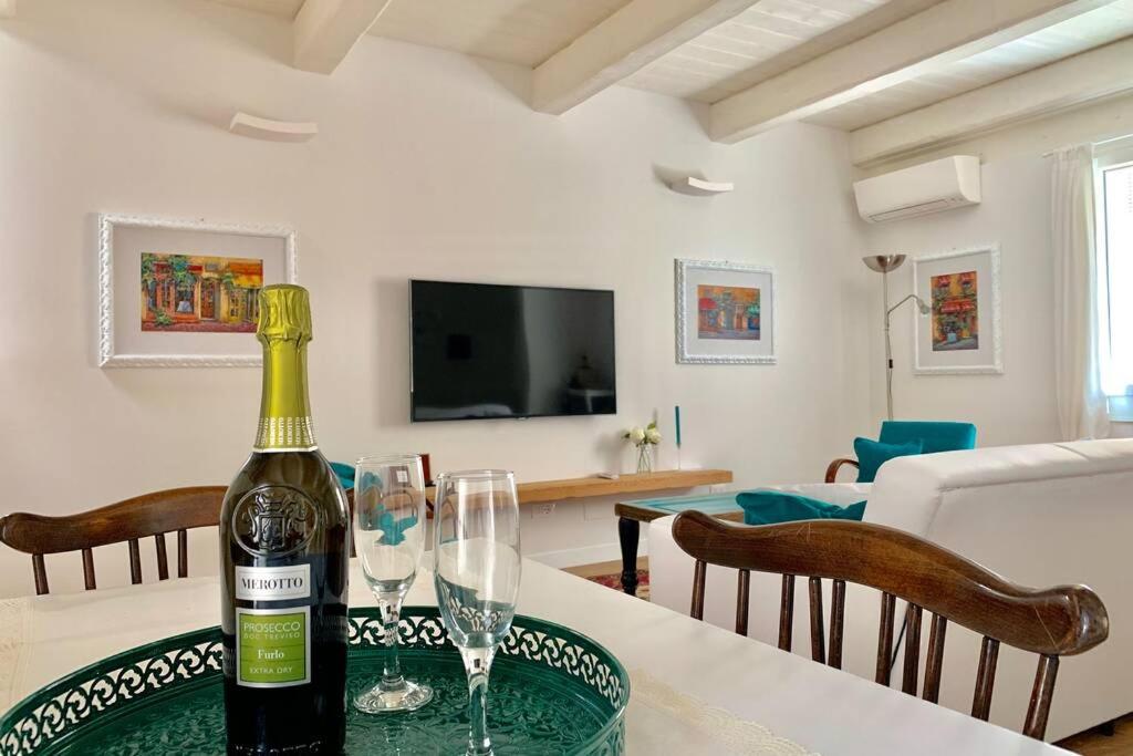a bottle of wine on a table in a living room at Casa Vicolo Castello in Ravenna