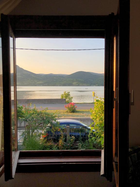 a window with a view of a body of water at Apartman Velojić in Donji Milanovac