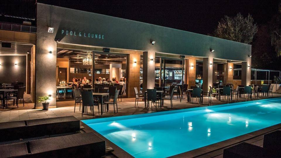 a restaurant with a swimming pool at night at Player's Pool&Rooms in Vonyarcvashegy