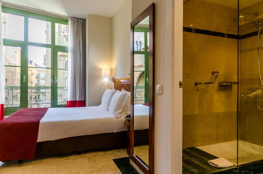 a hotel room with a bed and a shower at Exe Laietana Palace in Barcelona