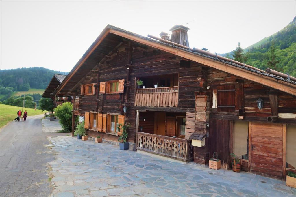 a wooden building with people walking in front of it at LACHAT appartement en chalet typique in Le Grand-Bornand
