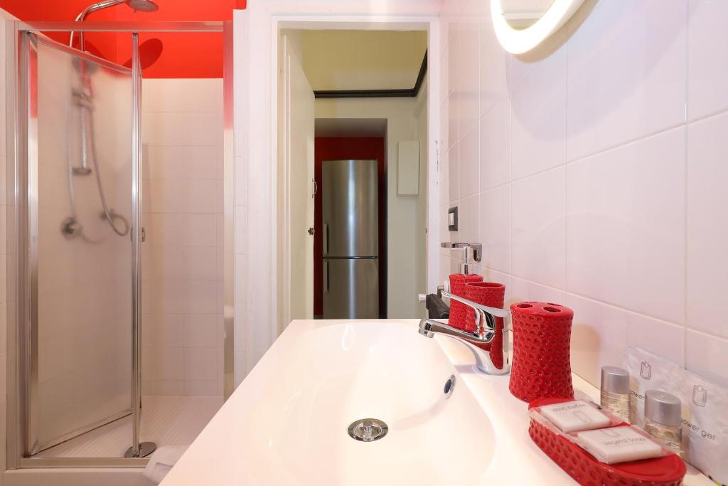 biała łazienka z umywalką i lustrem w obiekcie Grand Tour Rome Apartment - Liberty Collection w Rzymie