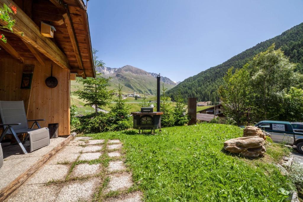 un cortile con griglia e montagne sullo sfondo di Ferienwohnung Haus Fliri a Melago