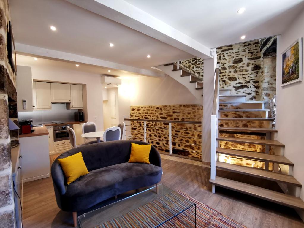 a living room with a couch and a staircase at Casa Anca Deluxe in Sarlat-la-Canéda