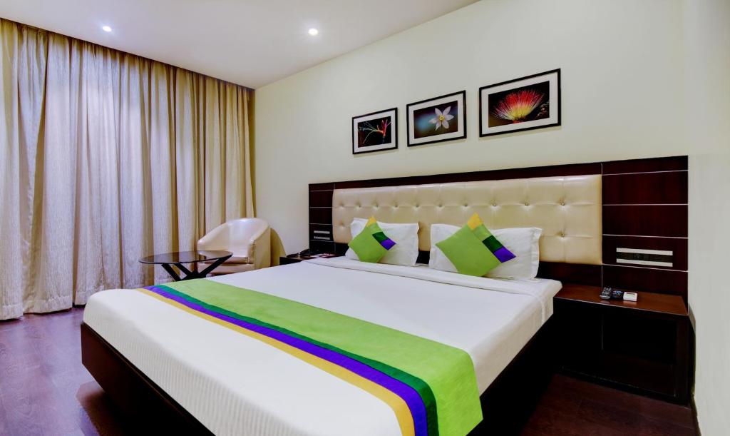 a bedroom with a large white bed in a room at Treebo Trend Primeland Suites in Bangalore